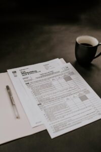 tax forms on table with black coffee mug on the side